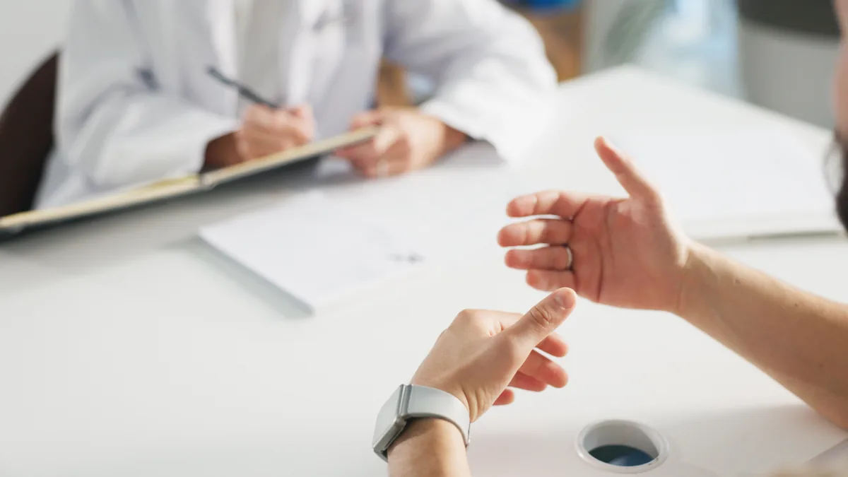 A patient talking with a doctor across a desk