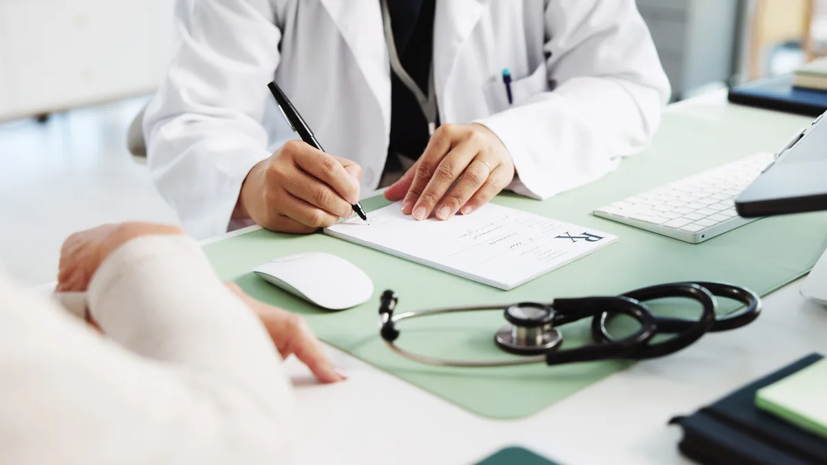 A doctor writing notes during a consultation